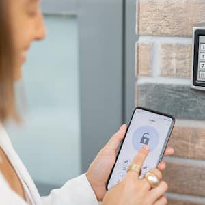 woman using phone to smart lock house